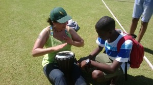 Ms Chapman getting drumming lessons from Lusindiso